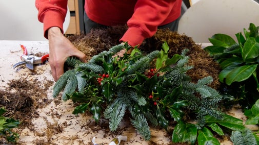 A close-up view of a person making a Christmas wreath